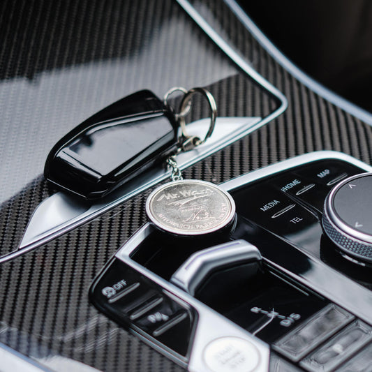 Schlüsselanhänger, silberfarben, Heritage, große Waschmünze Nr. 3 auf Auto-Mittelkonsole